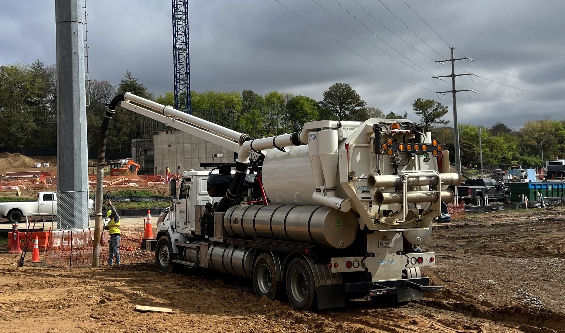 Construction worker performing utility locating work with a vac truck vactor 2100